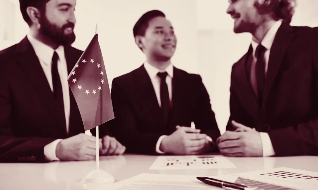 European Union flag and policy documents on a negotiating table, wine-toned