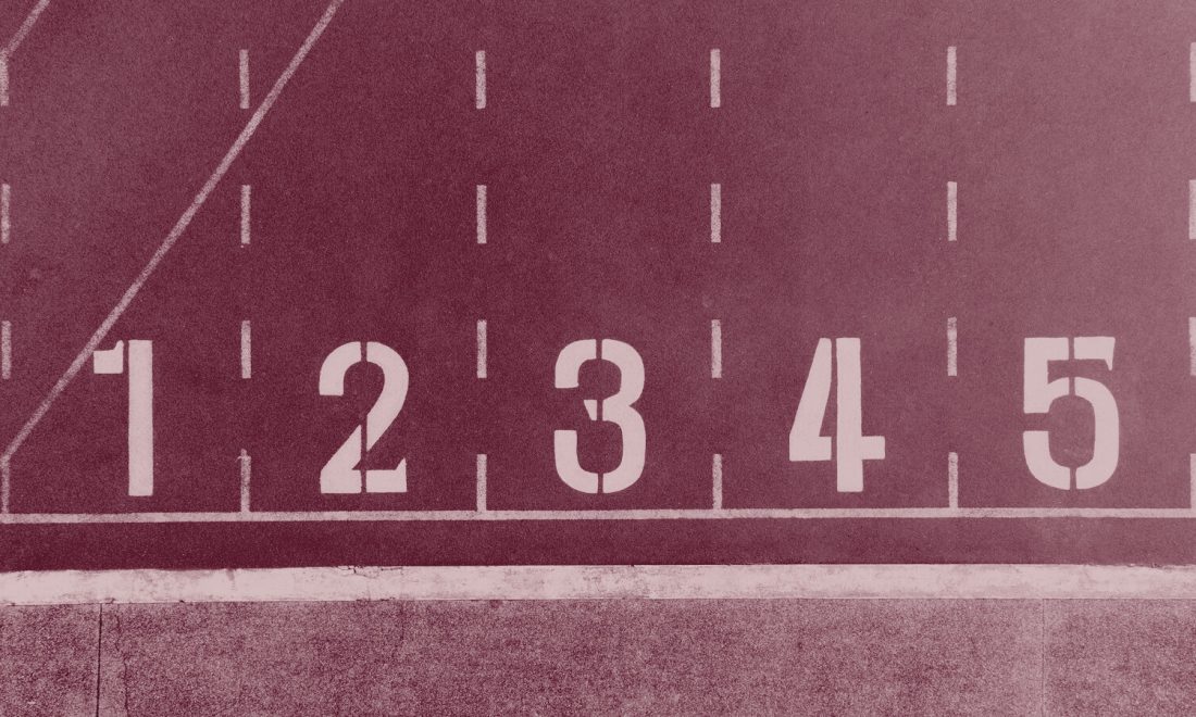 Numbered lanes one to five painted on a running track, seen from above