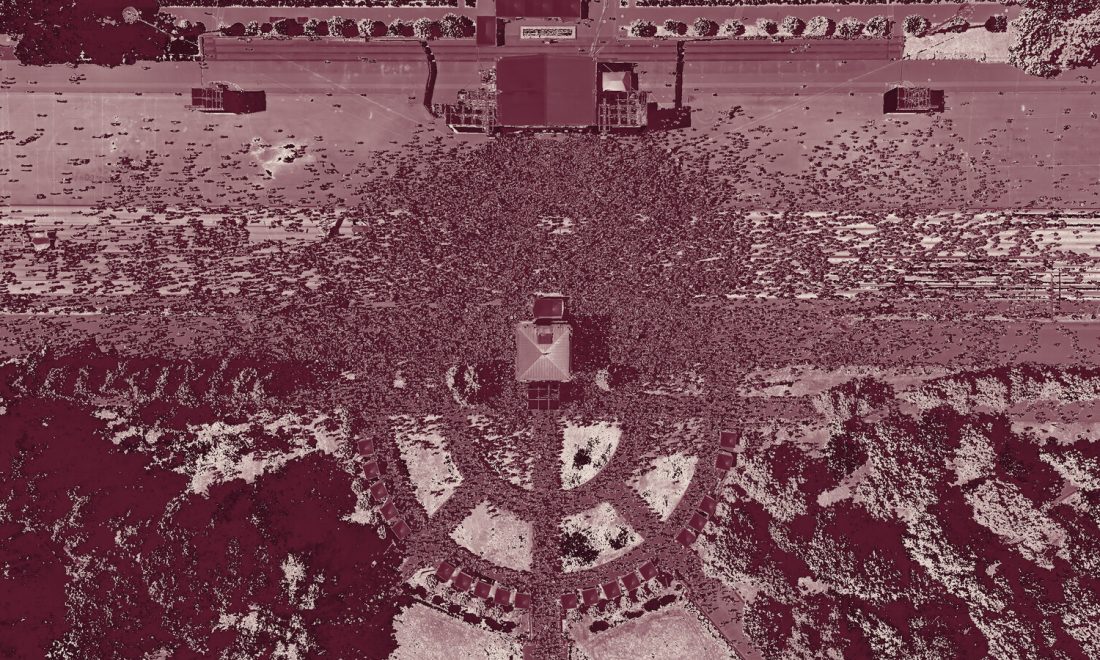 Aerial view of a vast crowd in wine monochrome, individuals indistinguishable in the mass