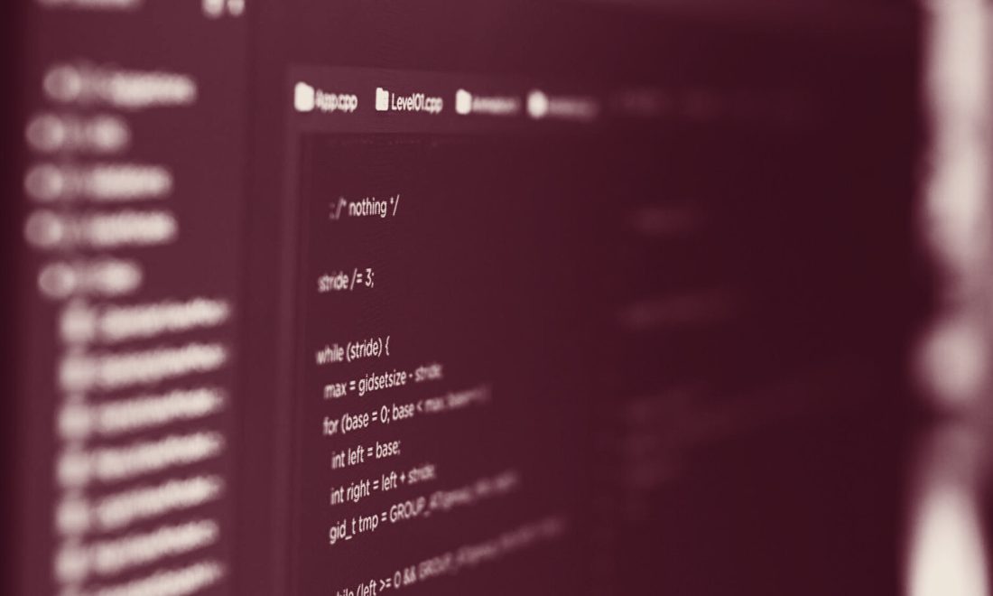 Blurred source code on a dark screen in wine tones