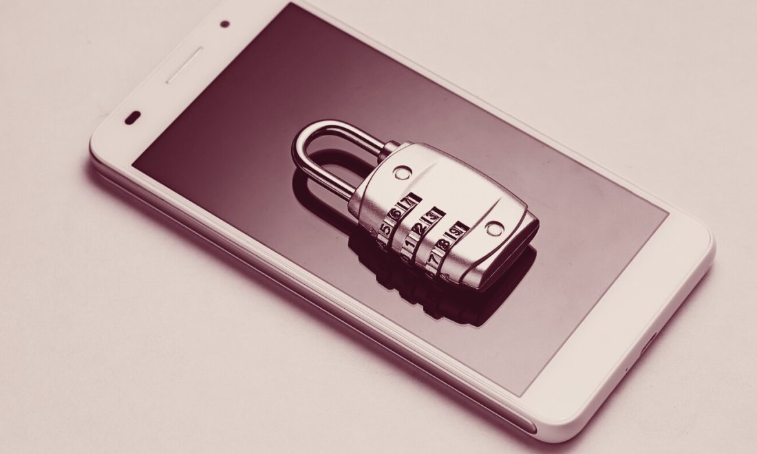 Combination padlock lying on a smartphone's dark screen, in wine tones